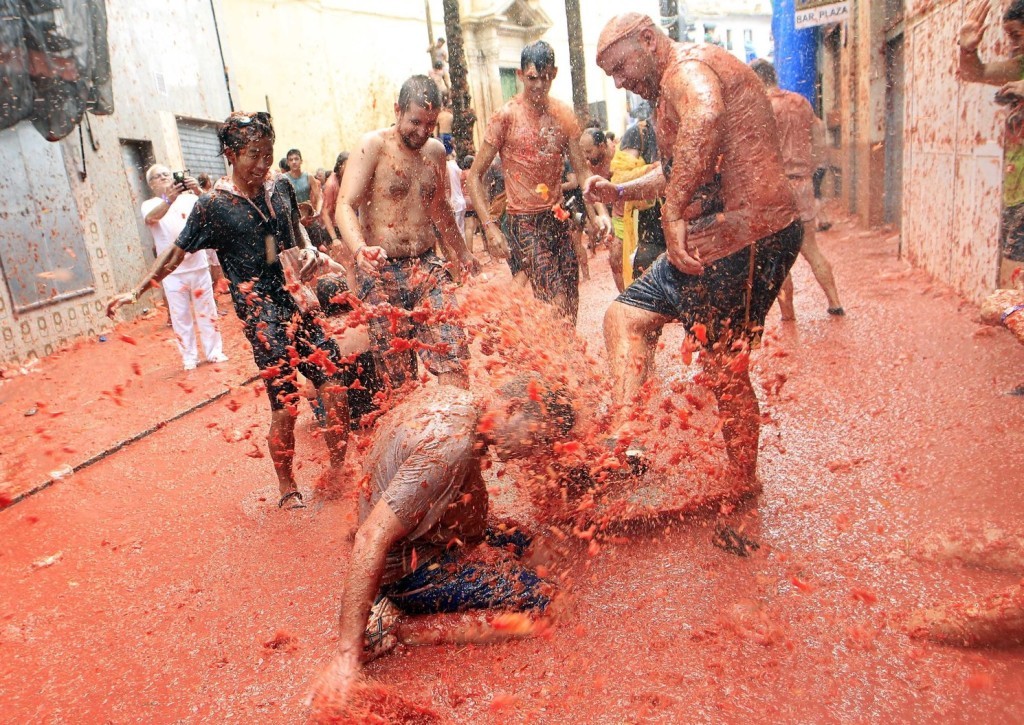 Paradicsomlében birkózó emberek a kelet-spanyolországi Bunolban évente megrendezett Tomatina fesztiválon 2017. augusztus 30-án. Az augusztus utolsó szerdáján megtartott hagyományos paradicsomcsata az 1940-es évekre nyúlik vissza. Az idén 160 tonna paradicsomot dobálnak szét a mulatságban résztvevők. (MTI/AP/Alberto Saiz)